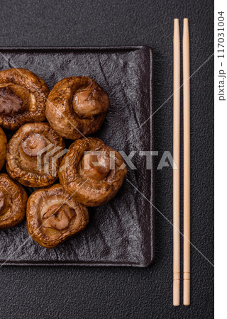 Delicious juicy whole champignons baked on the grill with salt and spices Delicious juicy whole champignons baked on the grill with salt and spices 117031004