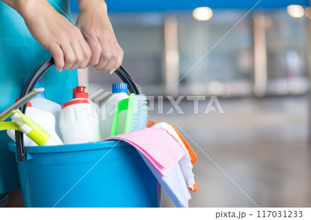 Professional cleaner with a bucket of cleaning products. 117031233