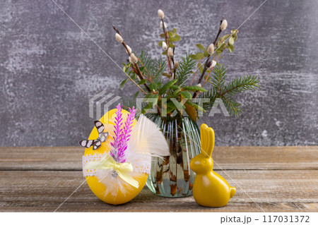 Wooden table with Easter bunny, egg and bunch of willow. 117031372