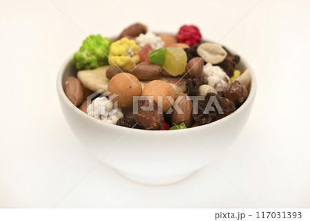 Sweet assorted nuts and dried fruits in a plate on a white background. 117031393