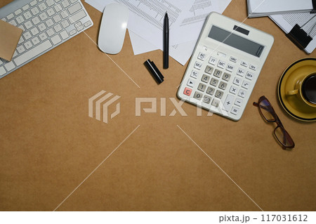 Top view of calculator, accounting documents and eyeglasses on brown background with space Top view of calculator, accounting documents and eyeglasses on brown background with space 117031612