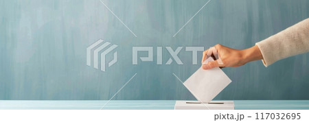 Hand Inserting Ballot Into Light Blue Box Against Teal Background 117032695