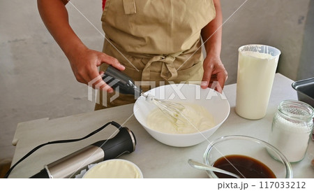 Housewife woman chef in kitchen apron cooking, preparing Italian meal in the home kitchen Housewife woman chef in kitchen apron cooking, preparing Italian meal in the home kitchen 117033212