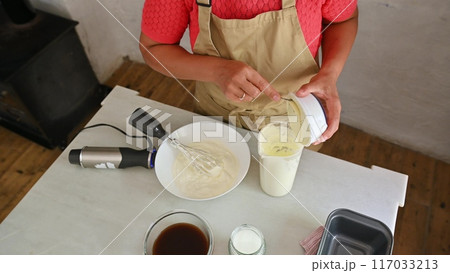 Housewife woman chef in kitchen apron cooking, preparing Italian meal in the home kitchen Housewife woman chef in kitchen apron cooking, preparing Italian meal in the home kitchen 117033213