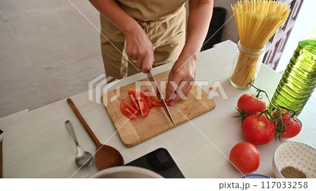Housewife woman chef in kitchen apron cooking, preparing Italian meal in the home kitchen Housewife woman chef in kitchen apron cooking, preparing Italian meal in the home kitchen 117033258