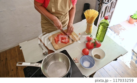 Housewife woman chef in kitchen apron cooking, preparing Italian meal in the home kitchen 117033259