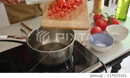 Housewife woman chef in kitchen apron cooking, preparing Italian meal in the home kitchen Housewife woman chef in kitchen apron cooking, preparing Italian meal in the home kitchen 117033261