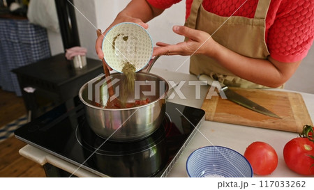 Housewife woman chef in kitchen apron cooking, preparing Italian meal in the home kitchen 117033262