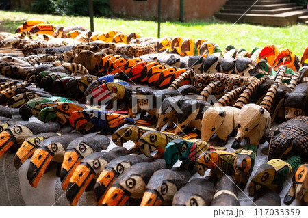 A vibrant collection of handcrafted wooden animal figures displayed at a market A vibrant collection of handcrafted wooden animal figures displayed at a market 117033359