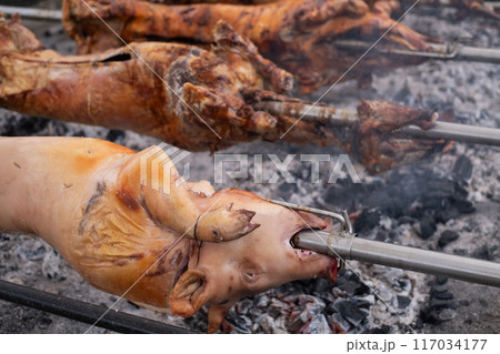 A pig grilled traditional coal and fire.  117034177