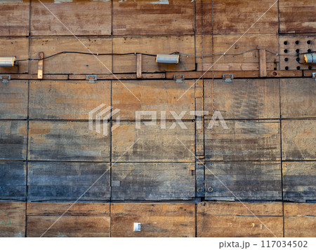 Communications on a wooden wall. Wires on the wall. Lamps and wiring on a wooden surface. 117034502