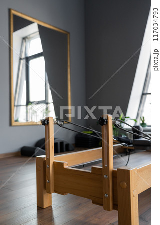 Pilates equipment. Reformer bed. Reformer pilates studio machine for fitness workouts in gym. Fit, healthy and strong authentical body. Fitness concept 117034793