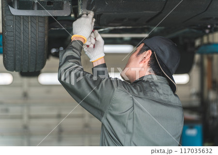 リフトに上がる車両の下で整備・点検・作業をする自動車整備士の男性 117035632