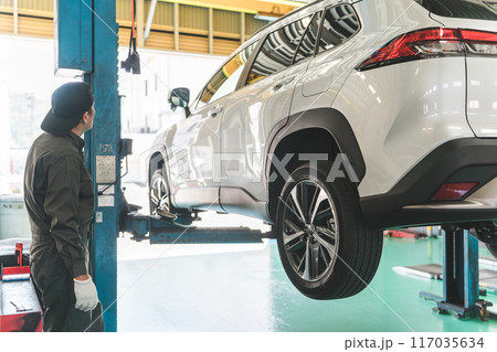 整備工場で車両をリフトアップする整備士の男性 117035634