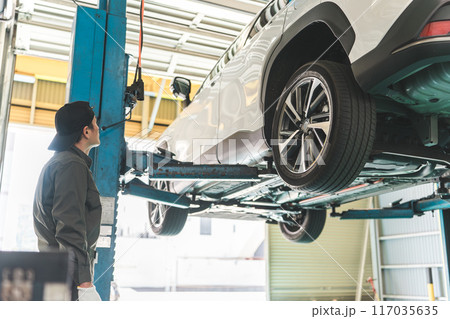 整備工場で車両をリフトアップする整備士の男性 117035635