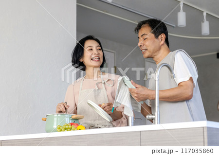 キッチンに立つミドル夫婦 117035860