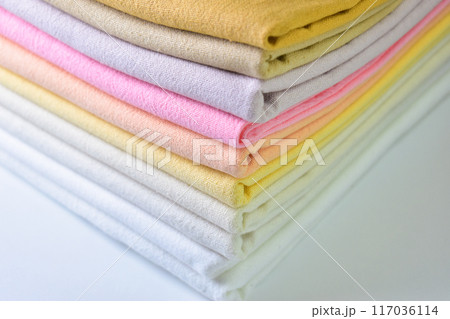 stack of colourful cotton clothes, pile of clothing on white background stack of colourful cotton clothes, pile of clothing on white background 117036114