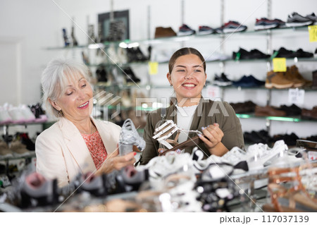Young woman with elderly mother is choosing sandals 117037139