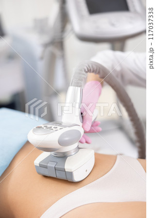 LPG massage device applied on young woman's belly 117037338