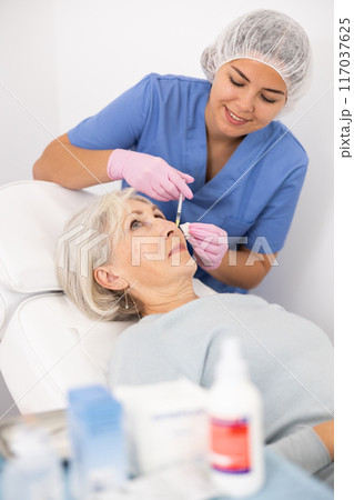 Old woman having mesotherapy procedure on her face Old woman having mesotherapy procedure on her face 117037625
