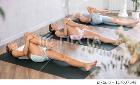 Teenage girl doing yoga in group in studio 117037648