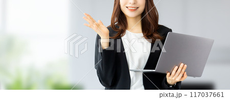 パソコンを持って案内をする笑顔の日本人ビジネスウーマン	 117037661