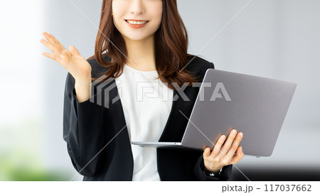 パソコンを持って案内をする笑顔の日本人ビジネスウーマン	 117037662