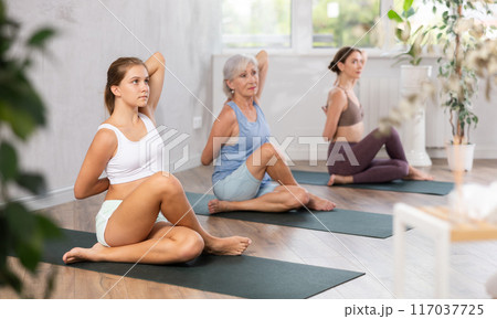 Teenage girl doing yoga in group in studio Teenage girl doing yoga in group in studio 117037725