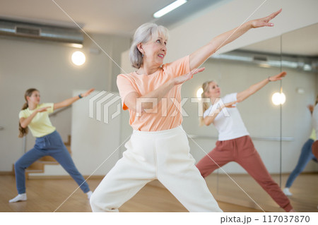 Senior woman performing contemporary dance in studio Senior woman performing contemporary dance in studio 117037870