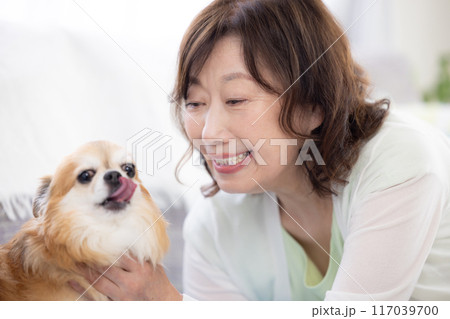 ペットの犬とくつろぐシニア女性 117039700