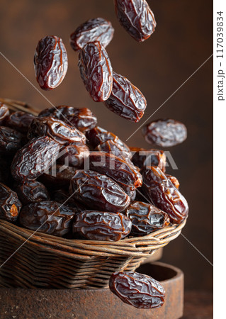 Dates in a old basket on a brown background. Dates in a old basket on a brown background. 117039834