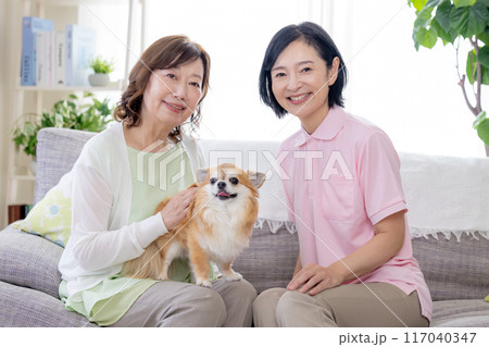 介護 ソファーで犬を可愛がるシニア女性と介護士 介護 ソファーで犬を可愛がるシニア女性と介護士 117040347
