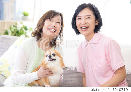 介護 ソファーで犬を可愛がるシニア女性と介護士 介護 ソファーで犬を可愛がるシニア女性と介護士 117040719