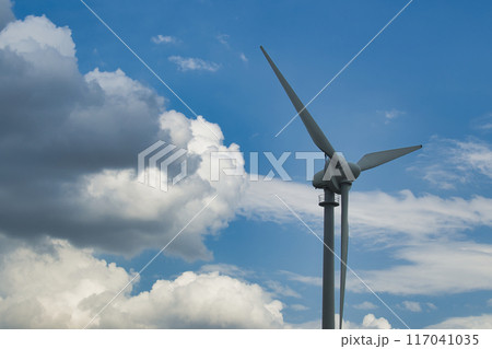Wind turbine against a backdrop of cloudy and clear blue sky capturing renewable energy Wind turbine against a backdrop of cloudy and clear blue sky capturing renewable energy 117041035