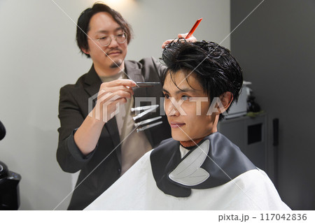 髪を切る男性美容師 117042836