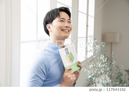 窓辺で投資の本を読む男性 117043192