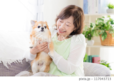 ペットの犬とくつろぐシニア女性 117043713