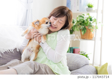 ペットの犬とくつろぐシニア女性 117043714