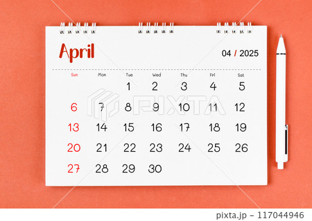 April 2025 Monthly desk calendar for 2025 year and pen on red. April 2025 Monthly desk calendar for 2025 year and pen on red. 117044946