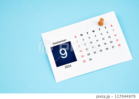 September 2024 calendar page with push pin on blue background. September 2024 calendar page with push pin on blue background. 117044979