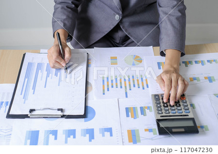 Asian businesswoman sit at their desks and calculate financial graphs showing results about their investments and plan successful business growth process Asian businesswoman sit at their desks and calculate financial graphs showing results about their investments and plan successful business growth process 117047230