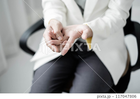 Woman hand with wrist pain numbness and pain in the palm of the hand has pain and tingling in the nerve endings This is a side effect of sitting and working for a long time on a laptop at the office Woman hand with wrist pain numbness and pain in the palm of the hand has pain and tingling in the nerve endings This is a side effect of sitting and working for a long time on a laptop at the office 117047806