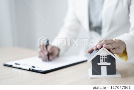 agents working in real estate investment and home insurance signing contracts in accordance with the home buying insurance agreements approving purchases for clients 117047861