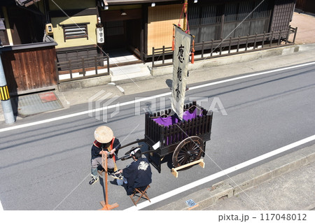 日本の岐阜県高山市　春の高山祭　法被を着て陣笠を被っている男性　古い台車を置いて休憩する姿 117048012