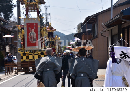 日本の岐阜県高山市　春の高山祭　屋台と呼ばれる豪華な山車　着物を着て陣笠を被っている男性の後ろ姿 117048329