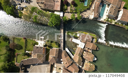 Beautiful panoramic aerial view of the mill village of Borghetto sul Mincio in the south of Lake Garda, in Veneto, Italy. Drone footage of the small medieval village 117049408