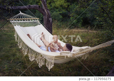 dad playing with his baby daughter in a hammock 117050275