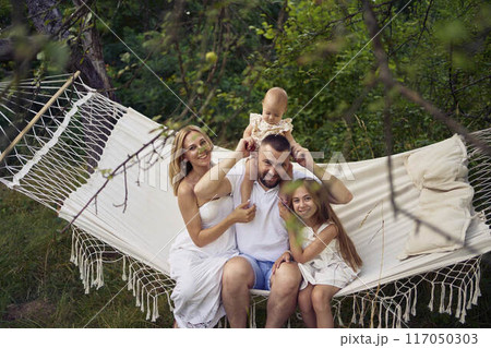 family mother father sister teenager and baby in hammock 117050303