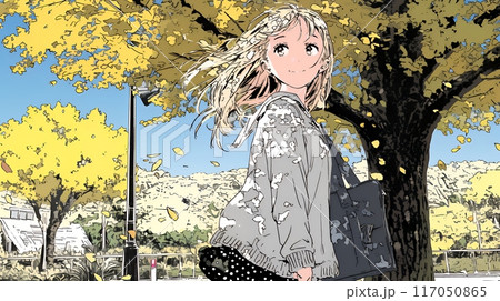 色づいたイチョウの木の下を歩く若い女性