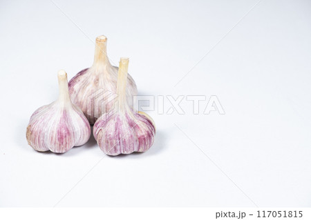 Three unpeeled fresh bulbs of garlic on a white isolate background, copy space for text Three unpeeled fresh bulbs of garlic on a white isolate background, copy space for text 117051815